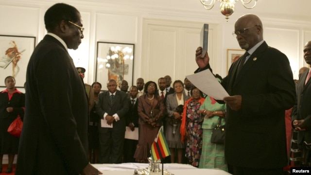 Zimbabwe President Robert Mugabe swears in then-Vice President John Nkomo, Harare, Dec. 14, 2009.