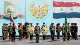 In this photo released by the Syrian official news agency SANA, Syrian honor guard soldiers carry the coffins of Syrian army soldiers who were killed in recent violence in the country, during their funeral procession at the military hospital, in Damascus,