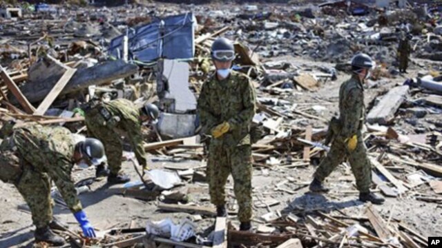 Japan Ground Self-Defense Force members sift through the rubble in the area devastated by the March 11 tsunami and earthquake in the town of Yamamoto, Fukushima Prefecture, Japan,  April 24, 2011