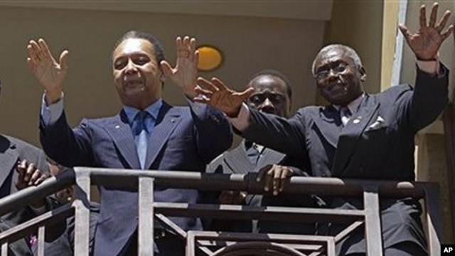 Haiti's former dictator Jean-Claude 'Baby Doc' Duvalier, left, greets supporters from the balcony of his hotel room in Port-au-Prince, Haiti, Wednesday Jan. 19, 2011. At right is Jouvert Pascal who is part of Duvalier's entourage. (AP Photo/Ramon Espinosa