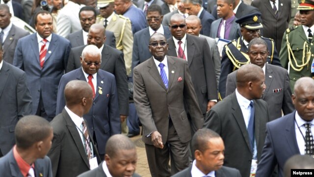 Zimbabwe's President Robert Mugabe (C) and Mozambique's President Armando Guebuza (2nd L red tie) arrive with other regional leaders for a summit of the Southern African Development Community in Mozambique's capital Maputo, August 17, 2012.