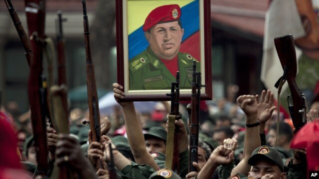 Miembros de la Milicia Nacional Revolucionaria, también llamados fuerzas bolivarianas, levantan sus armas como homenaje al presidente de Venezuela, Hugo Chávez.