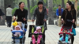Women push babies in prams through a Beijing park during a public holiday, April 5, 2011.
