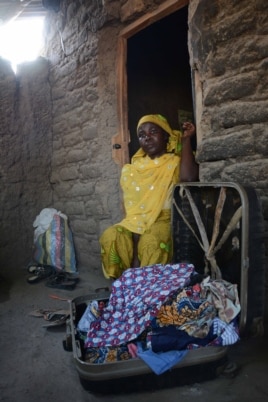 Yana Galang keeps her daughter's clothes and other belongings in a suitcase for when she comes back. (Katarina Höije/VOA)