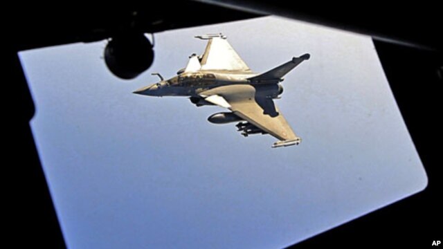 A French Rafale fighter jet approaches an airborne Boeing C-135 refueling tanker aircraft from the Istres military air base during a refueling operation above the Mediterranean Sea, Mar 25 2011