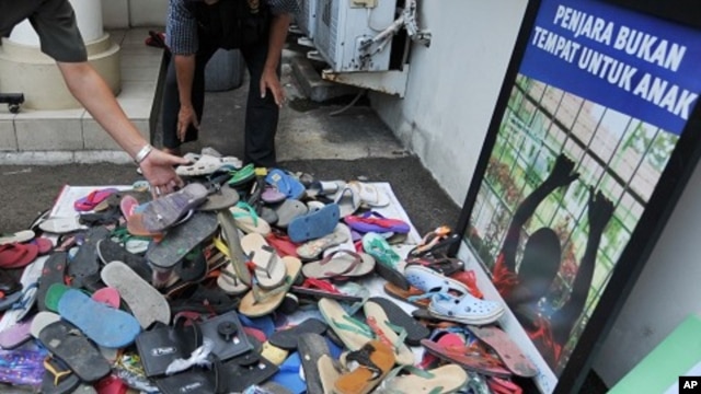 Officials from Indonesia's Child Protection Commission collect sandals sent to their office in Jakarta by outraged citizens as part of a campaign to support a boy who was beaten by police and faces five years in jail for stealing footwear, January 4, 2012