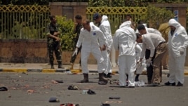 Forensic policemen inspect the site of a suicide bomb attack at a parade square in Sanaa, Yemen, May 21, 2012. 
