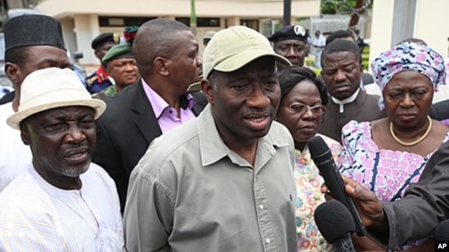 Nigeria President Goodluck Jonathan, center, speak to journalists, August 27, 2011 after visiting the explosion site at the United Nation's office in Abuja, Nigeria