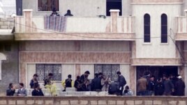 Members of the Free Syrian Army gather at a house in the northern Syrian town of Ras al-Ain, as seen from the Turkish border town of Ceylanpinar, Sanliurfa province, November 26, 2012. 