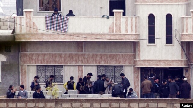 Members of the Free Syrian Army gather at a house in the northern Syrian town of Ras al-Ain, as seen from the Turkish border town of Ceylanpinar, Sanliurfa province, November 26, 2012. 