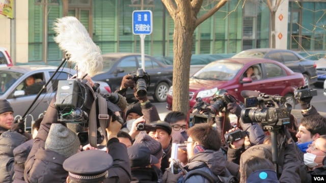 许志永的律师张庆芳与庭外外国记者交谈时，受到警察和便衣警察的阻挡，场面一度混乱(美国之音东方拍摄)