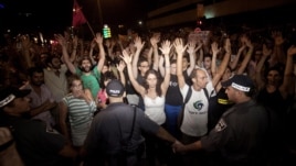 Israeli activists raise their hands during a social protest in Tel Aviv, June 24, 2012.