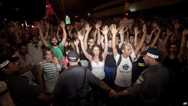 Israeli activists raise their hands during a social protest in Tel Aviv, June 24, 2012.