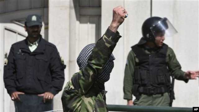 A demonstrator chants slogans in front of the Bahraini Embassy in Tehran, Iran as he covers his face in the style of Palestinian militants, in a protest against Saudi and Bahraini leaders to condemn the crackdown on the Bahraini opposition, April 15, 2011