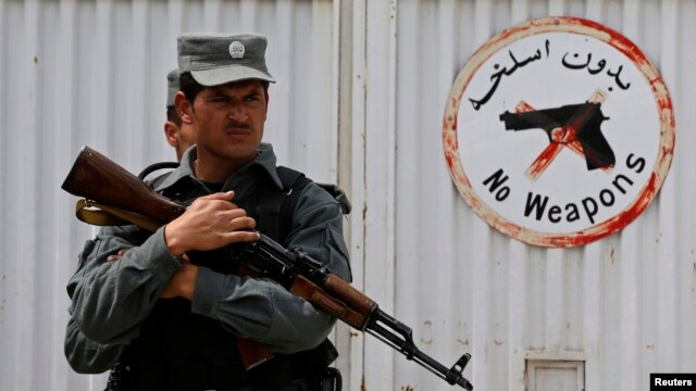 Cảnh sát Afghanistan canh gác trước cổng Bệnh viện Cure sau vụ nổ súng khiến 3 người Mỹ thiệt mạng.