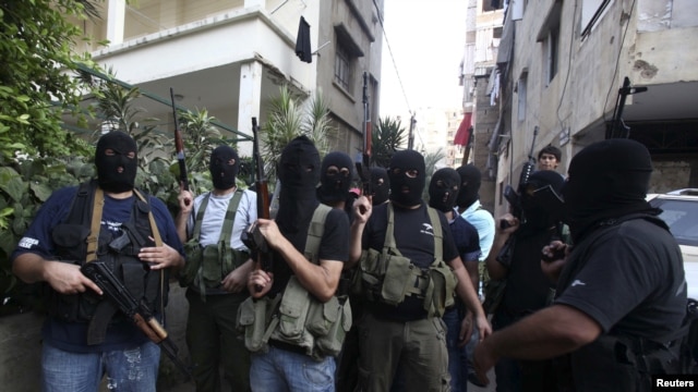 Shi'ite masked gunmen from the Meqdad clan, gather at the Meqdad family's association headquarters in the southern suburbs in Beirut, Lebanon, August 15, 2012.
