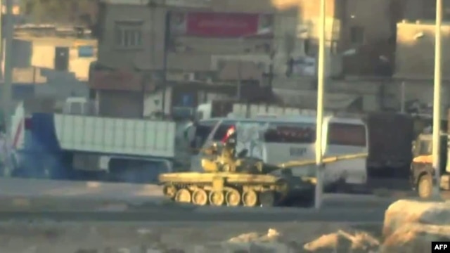 An image grab taken from a video uploaded on YouTube on August 22, 2012 allegedly shows a Syrian army tank deploying the the Nahr Aishe neighborhood of Damascus, August  22, 2012. 