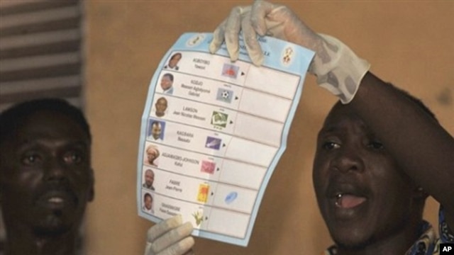 A Togolese electoral holds up a ballot papers in a polling station in Lome, 04 Mar 2010