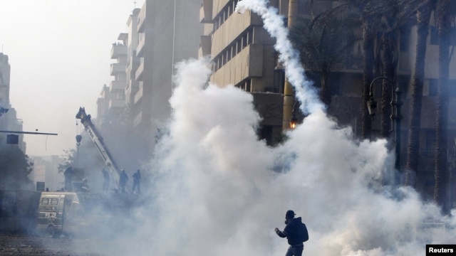 A protester throws a tear gas canister back at riot police in Cairo, November 25, 2012.