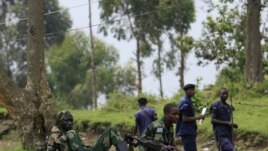 M23 rebel fighters watch the venue of a news conference by political leader Jean-Marie Runiga, in Bunagana, eastern DRC, in north Kivu province, July 21, 2012.