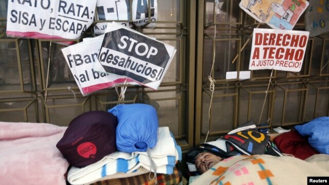 People sleep outside the headquarters of Spanish nationalized lender Bankia, where protesters have camped for more than three weeks, in Madrid, November 20, 2012.