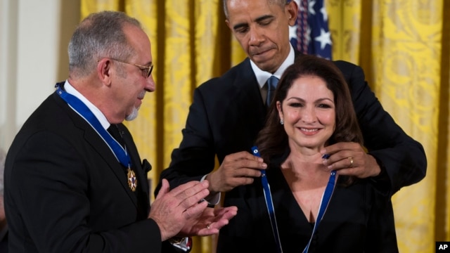 Emilio Estefan observa al presidente Barack Obama colocar a su esposa Gloria la Medalla Presidencial de la Libertad, durante una ceremonia en la Casa Blanca. Noviembre 24 de 2015.
