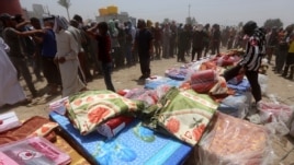 Iraqi families, who fled the city of Ramadi after it was seized by Islamic State militants, queue to receive aid at a camp for the internally displaced in Amriyat al-Fallujah, 30 kilometers south of Fallujah, May 22, 2015.