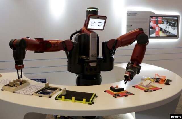 FILE - A Baxter robot of Rethink Robotics picks up a business card as it performs during a display at the World Economic Forum (WEF), in China's port city Dalian, Liaoning province, China onSept. 9, 2015.