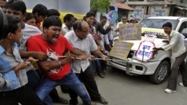 Indian people pull a car by rope and shout slogans during a protest against the price hike in diesel and capping the number of subsidized cooking gas cylinders in Ahmadabad, India, September 14, 2012.