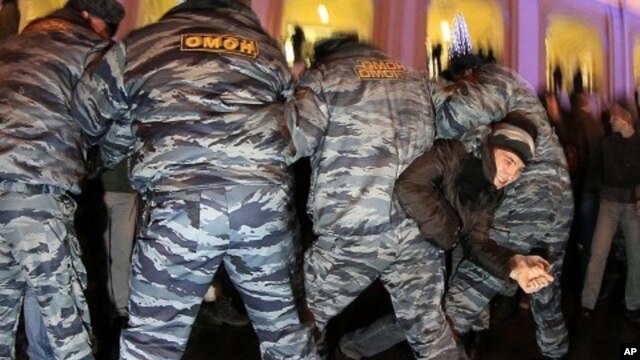 A protester tries to become free as police officers detain opposition activists during a protest against vote rigging in St.Petersburg, Russia, December 5, 2011.