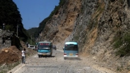  Two buses make their way across a road full of fallen rocks after a series of earthquakes, one of them measuring magnitude 5.7, hit the area near Zhaotong municipality at the border of southwest China's Yunnan and Guizhou province on September 7, 2012. 