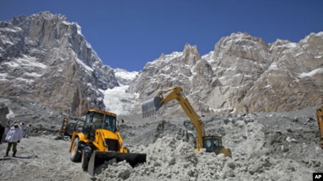 Pakistani soldiers use heavy machinery to dig through the snow at the site of an avalanche and landslide that struck a Pakistani army battalion headquarters, at the Siachen Glacier in Kashmir, April 18, 2012.
