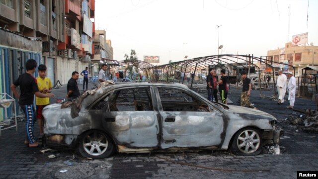 Cư dân Iraq tại hiện trường sau 3 vụ nổ bom chết người tại thành phố Sadr, ngày 22/9/2013. 