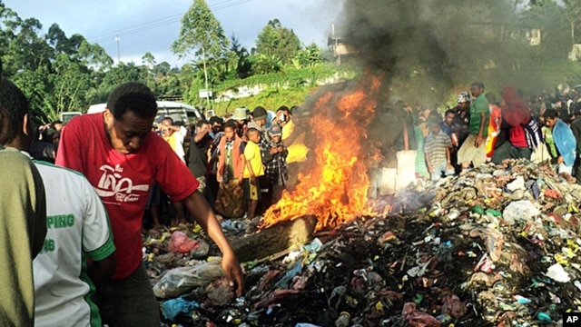 Penduduk menyaksikan seorang wanita yang dituduh mengunakan santet untuk membunuh bocah berusia enam tahun dibakar hidup-hidup di kota Mount Hagen, Papua Nugini (6/2).