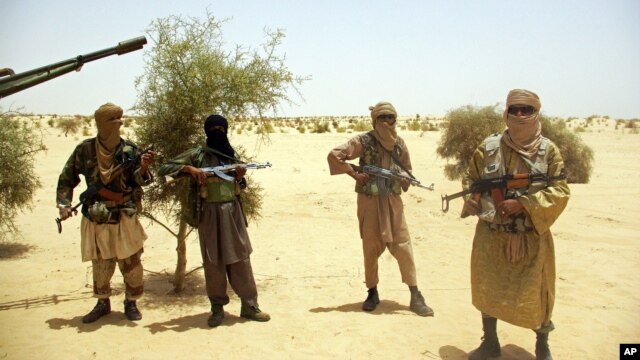 Ansar Dine Islamist fighters stand guard during a hostage handover in the desert outside Timbuktu, Mali, April 24, 2012.