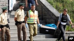 Сотрудники полиции у гостиницы, где проживал мигрант из Сирии до взрыва.. Ансбах, Германия, 25 июля 2016.