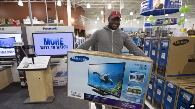 Jovel Cetoute, setelah mengantri selama berjam-jam di depan Best Buy di Pembroke Pines, Florida, mendapat televisi yang ia idam-idamkan (22/11).  