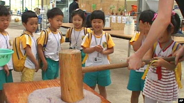 Summer camp kids get a hand with an old Asian tradition, with a twist - pounding rice cakes infused with blueberry juice