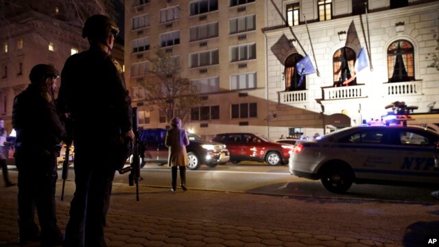 Policía de la Ciudad de Nueva York, fuertemente armados, hacen guardia frente al consulado francés en la Quinta Avenida.