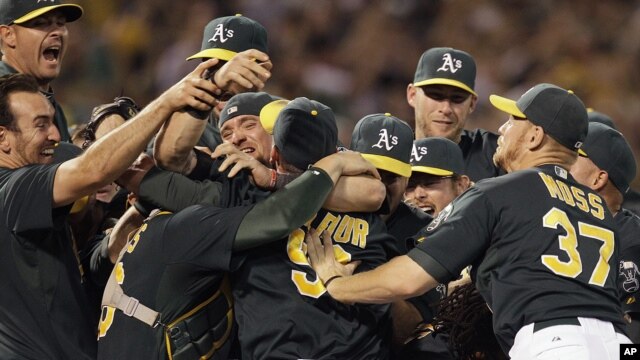 Jugadores de los Atléticos de Oakland celebran luego de conseguirse un comodín en la Liga Americana, al ganar a los Rangers de Texas, el lunes 1 de octubre de 2012.