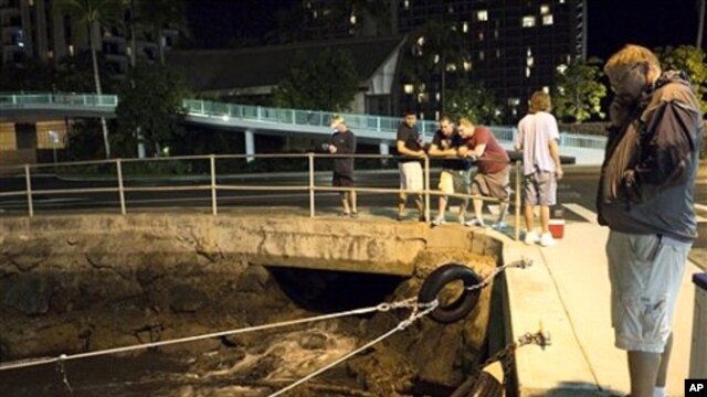 People watch the water recede from Hobron Harbor in Honolulu on  March 11, 2011. Tsunami waves swamped Hawaii beaches before dawn Friday but didn't cause any major damage after devastating Japan.