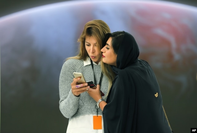 Journalists checkout the latest features of a mobile phone at the Apple Store ahead of their grand opening in Dubai, United Arab Emirates, Oct. 27, 2015.