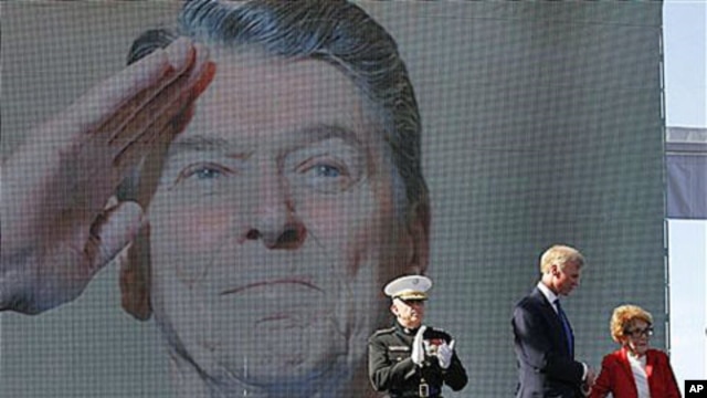 Former first lady Nancy Reagan is helped on stage by Frederick J. Ryan Jr., center, Reagan Foundation Chairman, as Marine Lt. Gen. George J. Flynn looks on after a wreath laying ceremony at memorial of her husband, former US President Ronald Reagan during