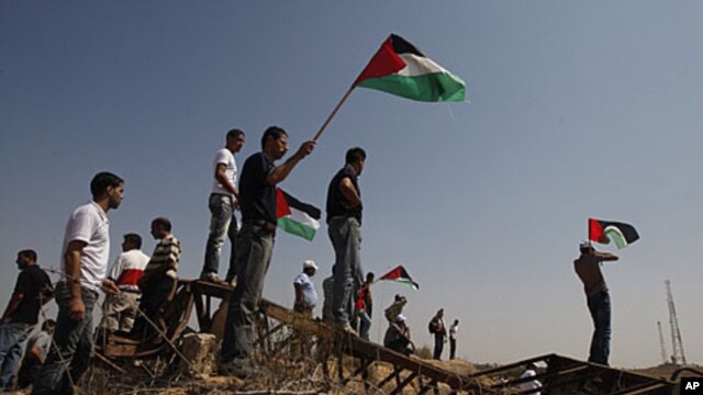 Palestinians hold Palestinian flags during a demonstration near the border between Gaza and Israel (file photo)