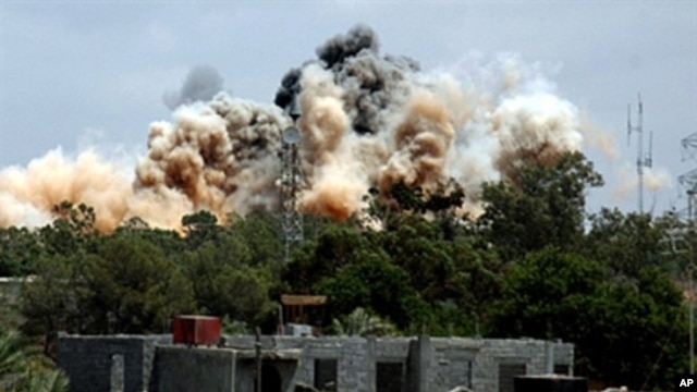 Smoke billows behind the trees following an air raid on the area of Tajura, 30 km east of Tripoli, when NATO unleashed its heaviest blitz yet of the area in a bid to speed up the ouster of Libyan leader Moammer Gadhafi, May 24, 2011