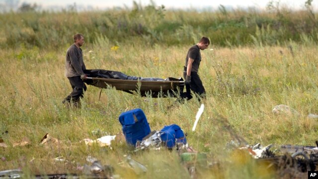 Nhân viên Bộ tình huống khẩn cấp Ukraine khiêng thi thể nạn nhân tại hiện trường vụ rơi máy bay Malaysia gần làng Hrabove, miền đông Ukraine, ngày 19/7/2014.