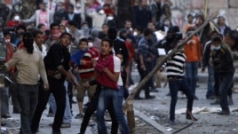 Anti-Morsi protesters throw stones towards riot police during clashes in Simon Bolivar Square, which leads to Tahrir Square, in Cairo, Egypt, January 30, 2013.