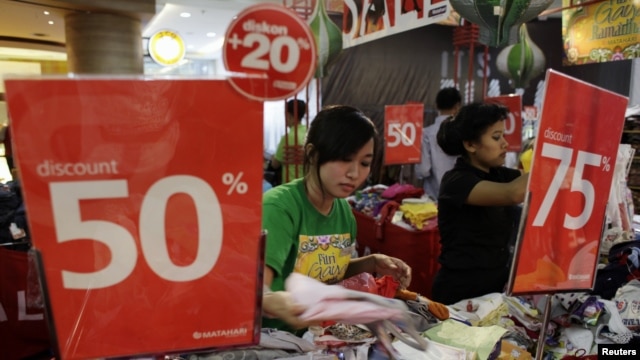 Employees prepare their clothes stall as they wait for customers at a shopping centre in Jakarta, August 6, 2012.  