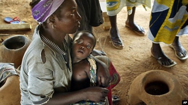Abdou Sawadogo, 3, is held by his mother as he waits to be given medicine by Red Cross workers at the Nicla II refugee camp, which houses people who have been driven from their land, in Guiglo in western Ivory Coast (File Photo)