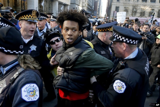 FILE - Lamon Reccord is taken into custody by Chicago police officers during a march calling for Chicago Mayor Rahm Emanuel and Cook County State's Attorney Anita Alvarez to resign, Dec. 9, 2015.